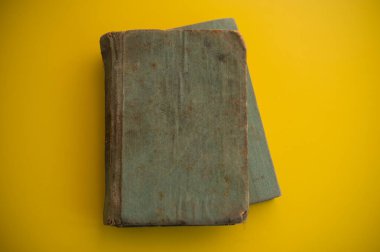 Sarı arka planda kirli kapaklı iki eski kitap yatıyor. Web afişi. Tasarım için.