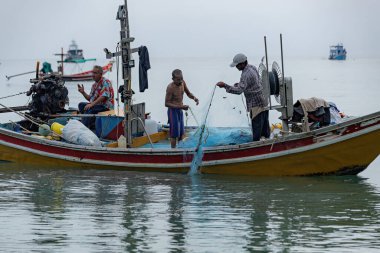 Hai balıkçıları Tayland 'ın Koh Tao kentindeki teknede balık ağını çözerler.
