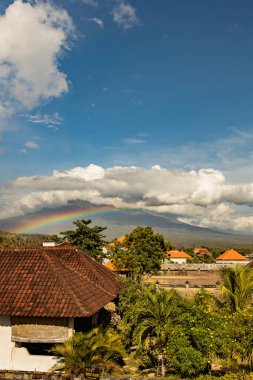 Beautiful rainbow over Agung volcano on sunny day Amed beach Bali Indonesia clipart