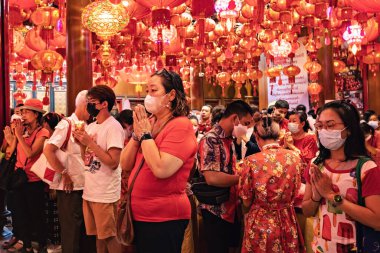 Mangkon temple people praying chinese new year Bangkok Thailand clipart