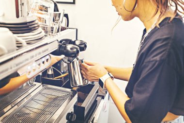 Barista preparing coffee at coffee machine. Coffee shop counter