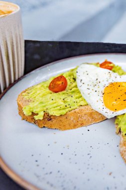 Classical breakfast close up toasts with avocado and sunny side egg