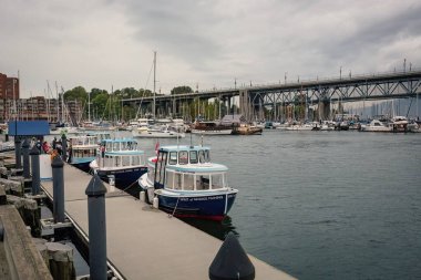 Granville Adası marinası ve Kanada şehir merkezinde False Creek yazan geleneksel tekneler.