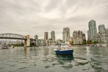 Granville Adası marinası ve Kanada şehir merkezinde False Creek yazan geleneksel tekneler.