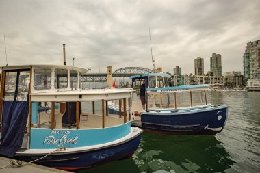 Granville Adası marinası ve Kanada şehir merkezinde False Creek yazan geleneksel tekneler.