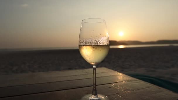 Witte Wijn Het Mistige Glas Tegen Zonsondergang Het Strand — Stockvideo