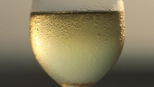 ビーチの夕日の空に対するミスグラスの中の白ワイン — ストック動画