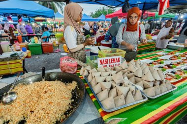 Malezya 'da gece pazarında Nasi Lemak (çeviri: hindistan cevizi pilavı) satan genç Malezyalı kadın