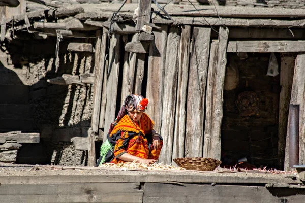 stock image Kalash woman wearing traditional clothes working near her house in Kalash village, Gilgit, Pakistan