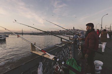  Güneşli bir günde İstanbul 'daki Galata köprüsünde balıkçılar, Türkiye