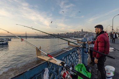  Güneşli bir günde İstanbul 'daki Galata köprüsünde balıkçılar, Türkiye