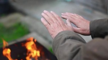 Adamın elleri şöminenin üstünde. Yaklaş. Ateşin yanında sıcak eller
