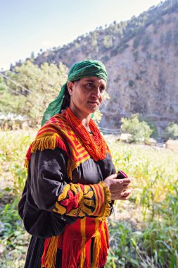 Kalaş Vadisi köyünde gülümseyen geleneksel giyinmiş Kalaş kabilesinden bir kadın.