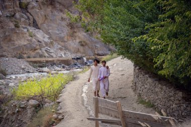 Pakistan 'da Kalash vadisinde köy yolunda yürüyen Pakistanlı adamlar