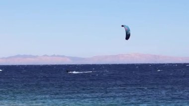 Uçurtma sörfçüsü, Mısır 'ın deniz feneri bölgesinde, Dahab' da dalgalarda sörf yapıyor.