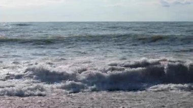 Fırtınalı deniz, sert dalgalar kayalık sahile çarpıyor.