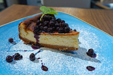 Lokantadaki mavi tabakta yabanmersinli cheesecake