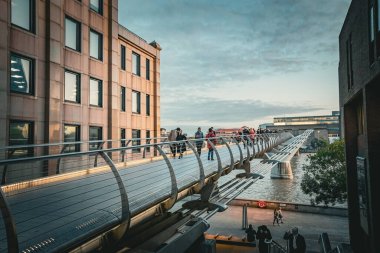 Londra 'daki Millennium Köprüsü' ndeki insanlar gün batımında, İngiltere 