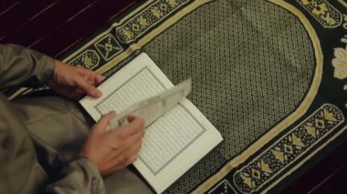  Müslüman adam Kuran 'ı kutsal bir paspasın üzerinde okuyor. Müslümanların duası şudur: 