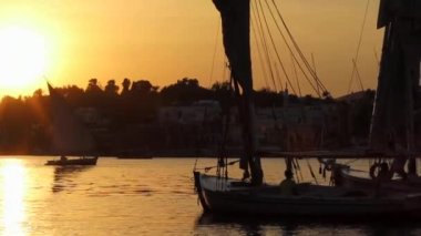 Günbatımında Nil 'de geleneksel felucca yelkenlisi, Aswan, Mısır