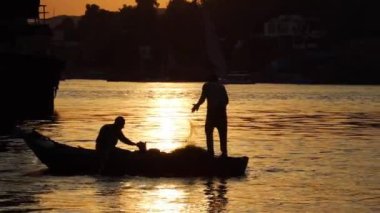 Nil nehrindeki balıkçılar, küçük ahşap bir teknede balık ağıyla balık avlıyorlar.