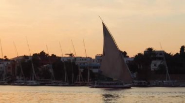 Günbatımında Nil 'de geleneksel felucca yelkenlisi, Aswan, Mısır