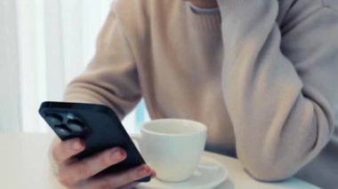 Akıllı telefon elleri beyaz çay fincanı kadın elleri yakın 