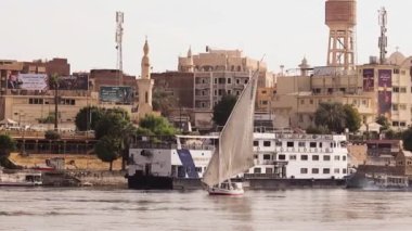 Günbatımında Nil 'de geleneksel felucca yelkenlisi, Aswan, Mısır