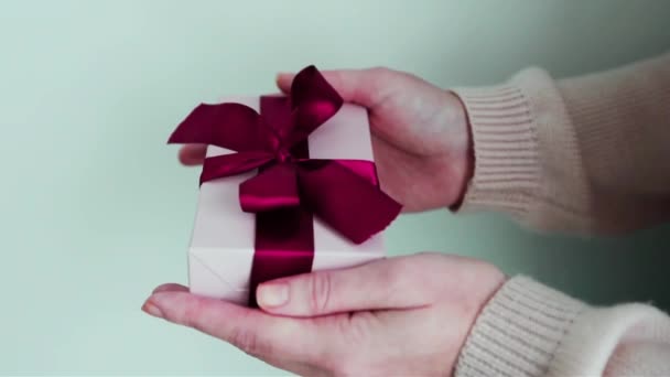 手牵着礼物的女人紧紧抓住柔软的粉色红带 — 图库视频影像