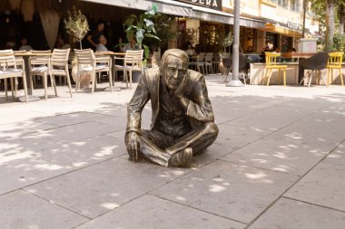 Priştine 'nin merkezinde oturan adam heykeli
