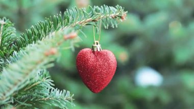 Kırmızı kalp ağaçtaki Noel oyuncağını şekillendirdi. Noel ve yeni yıl dekorasyonu.
