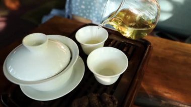 Çay seremonisi yapan kadın bardaklara Çin çayı dolduruyor. 