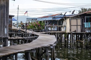 Fishing village houses over the water garbage poor areas in Sabah province in Malaysia clipart