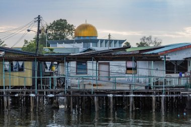 Fishing village houses over the water garbage poor areas in Sabah province in Malaysia clipart