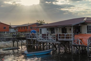 Fishing village houses over the water garbage poor areas in Sabah province in Malaysia clipart