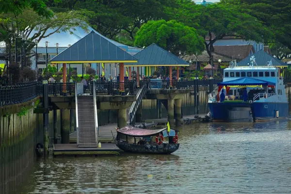 Kuching Borneo Malezya 'daki Sarawak nehrindeki geleneksel teknede kayıkçı.