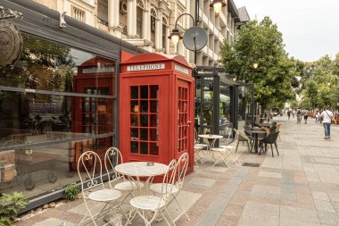 Red British telephone booth on the street of old town of Skopje North Macedonia clipart