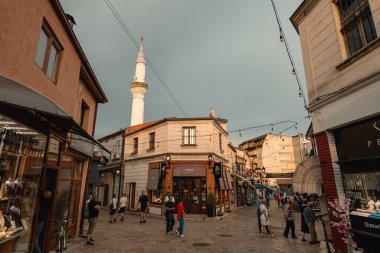 Üsküp 'ün eski kenti Kuzey Makedonya' daki dar pazar caddesinde yaşayan insanlar