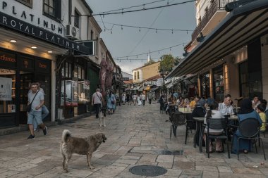 Üsküp 'ün eski kenti Kuzey Makedonya' daki dar pazar caddesinde yaşayan insanlar