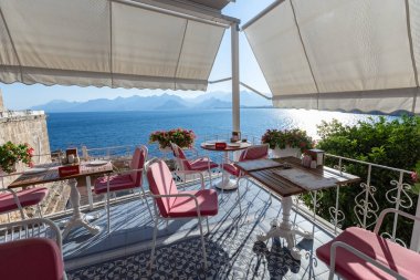Gün batımında deniz manzaralı güneşli teras kafe masaları