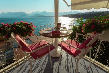 Gün batımında deniz manzaralı güneşli teras kafe masaları