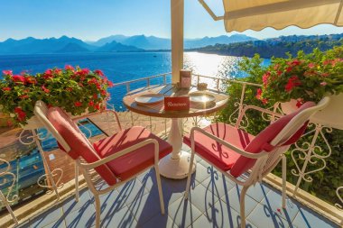 Gün batımında deniz manzaralı güneşli teras kafe masaları