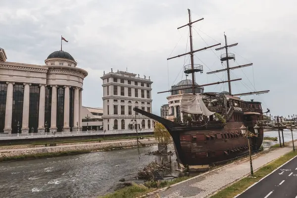 stock image Archaeological Museum of the Republic of Macedonia and Old sailing ship on the Vardar river in Skopje old town