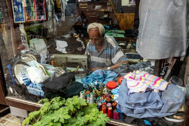 Üsküp 'ün eski bir kasabası olan Kuzey Makedonya' daki dikiş makinesinde çalışan bir işçiyle birlikte terzi.
