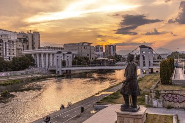 Üsküp 'ün Vardar nehri kıyısındaki şehir manzarası Kuzey Makedonya' da gün batımında