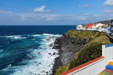 Bright houses on the cliff at Atlantic ocean coast in Azores islands Portugal clipart