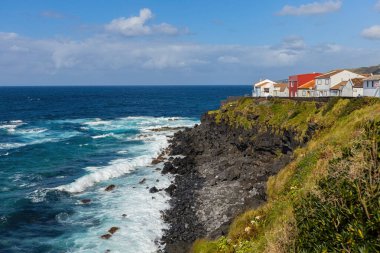 Portekiz 'in Azores adalarındaki Atlantik okyanus kıyısındaki uçurumlarda parlak evler