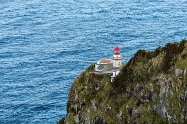 Lighthouse on the cliff at Terseira island Azores Portugal clipart