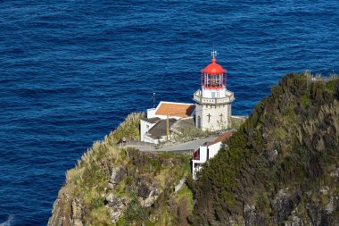 Lighthouse on the cliff at Terseira island Azores Portugal clipart