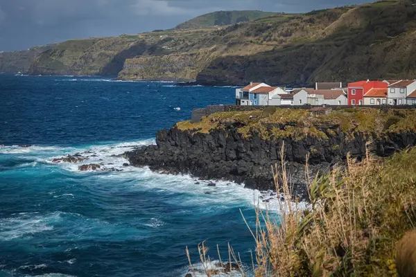 Portekiz 'in Azores adalarındaki Atlantik okyanus kıyısındaki uçurumlarda parlak evler